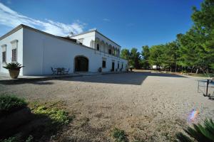 ein weißes Gebäude mit einem Picknicktisch davor in der Unterkunft Antica Masseria Jorche in Torricella