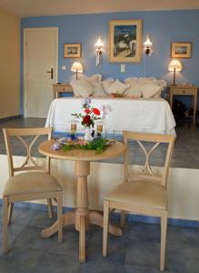 a bedroom with a bed with a table and two chairs at Fata Morgana in Chora Folegandros