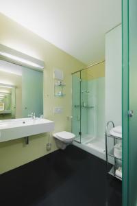 a bathroom with a sink and a toilet and a shower at Motel Z - self checkin in Feldkirch