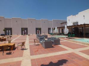 un patio con sillas, mesas y una piscina en Las Terrazas de La Torre Golf Resort 55 en Las Pedreñas