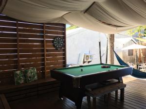 a pool table in a room with awning and a pool table at Slow Island Hostel in Green Island