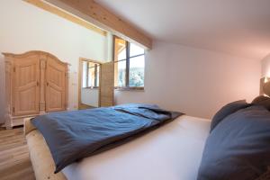 a bedroom with a bed and a large window at Seebacher Apartments in Sarntal