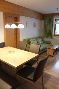 sala de estar con mesa y sofá verde en Ferienwohnung Claudia, en Fügenberg