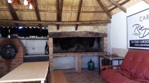 - un salon avec une cheminée et un canapé rouge dans l'établissement Cabañas Rio Diamante, à San Rafael