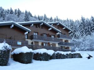 um alojamento de turismo selvagem na neve com árvores cobertas de neve em LES CARROZ LE LAYS cosy apartment 40M2 vue montagne plein sud em Les Carroz d'Arâches