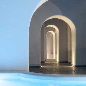 a swimming pool with an archway in a room at Antoperla Luxury Hotel & Spa in Perissa