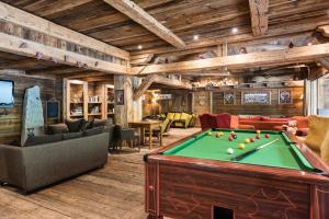 een woonkamer met een pooltafel in een lodge bij CGH Résidences & Spas La Ferme Du Val Claret in Tignes