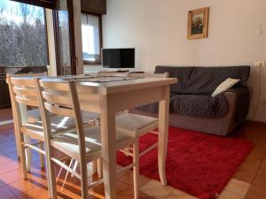 un soggiorno con tavolo, sedie e divano di Trentino Apartments - Casa Aurora a Folgaria