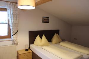 1 dormitorio con 1 cama grande con almohadas amarillas en Ferienwohnung Claudia, en Fügenberg