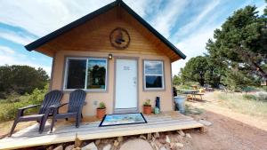 a tiny house with two chairs on a porch at White Pine Cabin by Canyonlands Lodging in Monticello