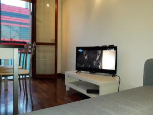 TV de pantalla plana con soporte blanco en la sala de estar en Maranello Suite, en Maranello