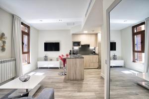 a kitchen and living room with white walls and windows at Apartamentos Cava Baja in Madrid