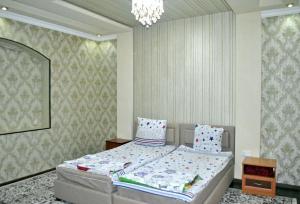 1 dormitorio con cama y lámpara de araña en HOtel Like, en Samarkand