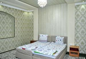 a bedroom with a bed and a chandelier at Like Guest House in Samarkand