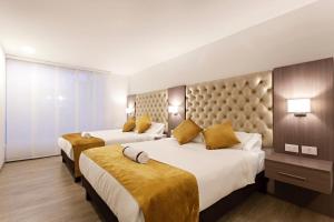 a hotel room with two beds with yellow pillows at Hotel Max in Pasto +22 photos