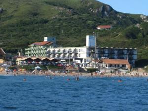 un grupo de personas en una playa en el agua en Cris Hotel en Florianópolis
