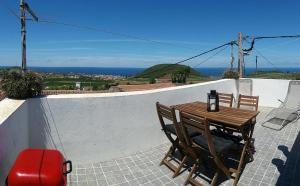 a table and chairs on a balcony with a view of the ocean at Fontes Viewpoint in Santa Cruz da Graciosa