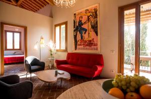 - un salon avec un canapé rouge et une table dans l'établissement Tuscany Forever Apartments 2, à Volterra