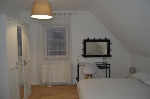 Au Pays de la Potasse في أونجيرشييم: غرفة نوم بسرير وتلفزيون على الحائط