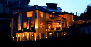 a large building with its lights on at night at Glory Bush Boutique Villa in Nuwara Eliya