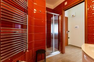 a bathroom with red tiles and a glass shower at Napoli d'Amare B&B in Naples