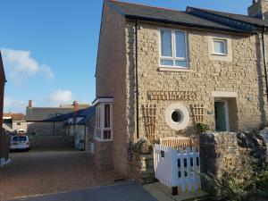 a brick house with a white fence in front of it at St Marks Cottage in Swanage