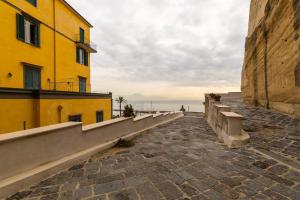 an empty street in front of a yellow building at Napoli d'Amare B&B in Naples