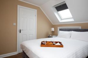 a bed with a wooden tray with a cat on it at Oxford City Boutique Home: "Oxford Collegiate Residence by AHG" in Oxford