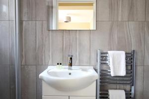 a bathroom with a sink and a mirror and towels at Oxford City Boutique Home: "Oxford Collegiate Residence by AHG" in Oxford +37 photos