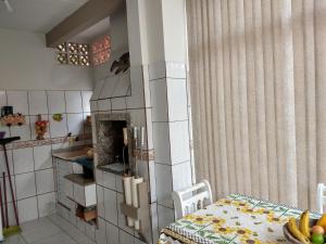 Una habitación con cocina con mesa y una habitación con en Casa Beira Mar Mariscal Terreo en Bombinhas