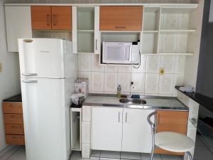 a small kitchen with a white refrigerator and a sink at Casa Central em Petrolina in Petrolina