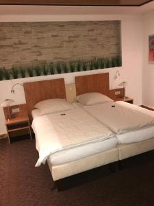 a bedroom with two beds and a wall with plants at tauwerk Hotel in Wilhelmshaven