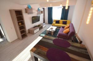 a living room with a purple couch and a tv at Rya Home 1 in Bucharest