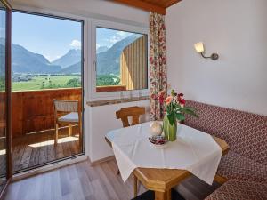 a room with a table and a balcony with mountains at Haus Raimund in Längenfeld