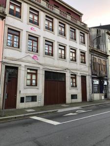 a white building with brown doors on a city street at Metro Heroismo Residence in Porto