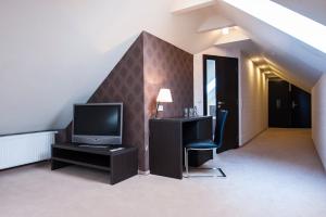 sala de estar con TV, mesa y silla en Markus, en Kolonowskie