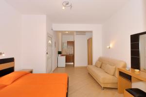 a living room with an orange bed and a couch at Villa Thomas Valtos beach in Parga +17 photos