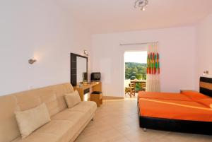 a living room with a couch and a bed at Villa Thomas Valtos beach in Parga