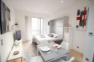 Sala de estar blanca con cama y mesa en Sparkle, en Cannes