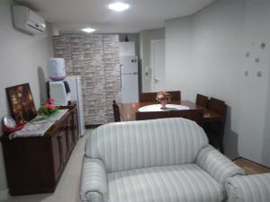 sala de estar con silla y cocina en Residencial Saul Bertemes, en Bombinhas