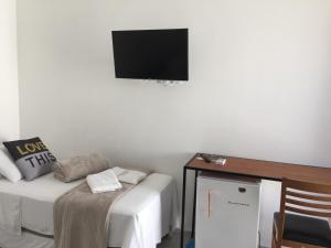 a room with a bed and a tv on the wall at Pousada CasaPark in Penha