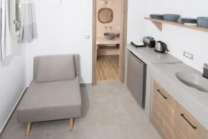 uma pequena cozinha com uma cadeira e um lavatório em Aeris suites em Koufonisia