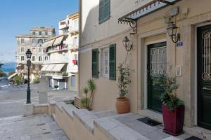 a building with plants on the side of a street at Artemis Apartment in Corfu Town
