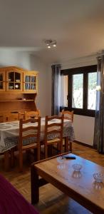 a living room with a table and a piano at Soldeu Paradis Soldeu in Soldeu