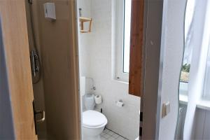 ein kleines Badezimmer mit Toilette und Fenster in der Unterkunft Stern Hotel in Leipzig + 37 Fotos