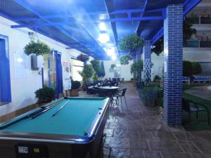 a pool table in a room with tables and chairs at Playamarina I in Cabo Roig