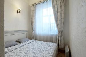 a small bedroom with a bed and a window at Provence Home in Vilnius