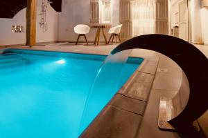 una piscina con agua azul en una habitación en Aeris suites, en Koufonisia