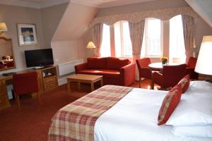 a hotel room with a bed and a couch and a tv at Atholl Hotel in Aberdeen