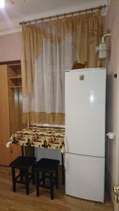 リヴィウにあるАпартаменты на Антоновичаの冷蔵庫、窓の前のベッドが備わる客室です。